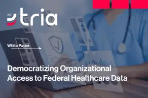 A healthcare professional enters data into a laptop.